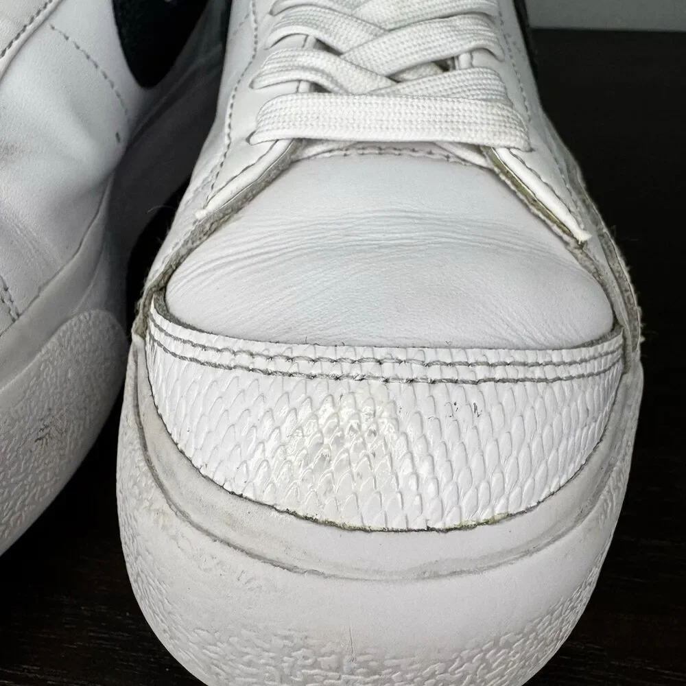 Nike White Leather Low-Top Sneakers with Black Swoosh and Yellow Tongue
